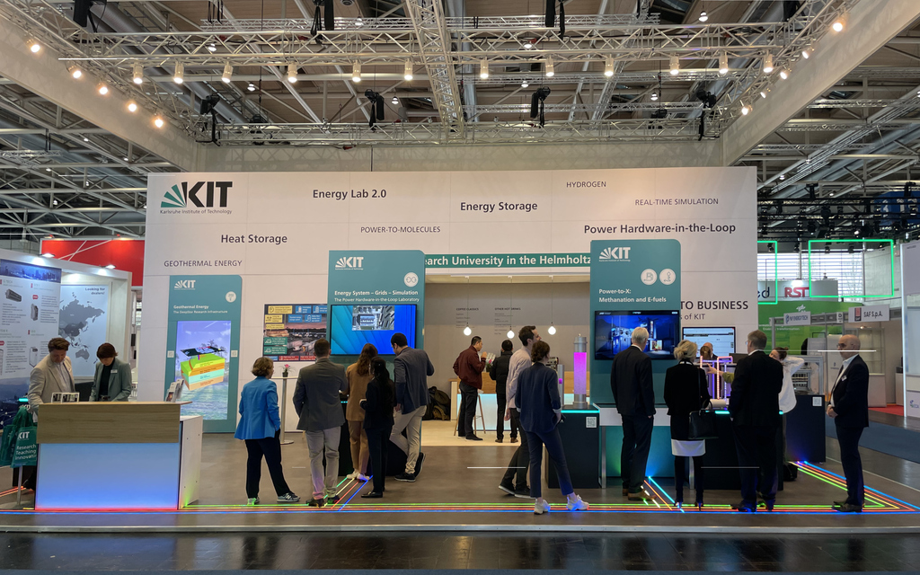 Forschung für die Energiewende wird auf der Hannovermesse am Stand des KIT gezeigt. Das Energy Lab stellt Exponate u.a. zur Methanisierung und E-Fuels aus grünem Strom  zur Schau. Viele Leute stehen bei den Exponaten und betrachten sie.